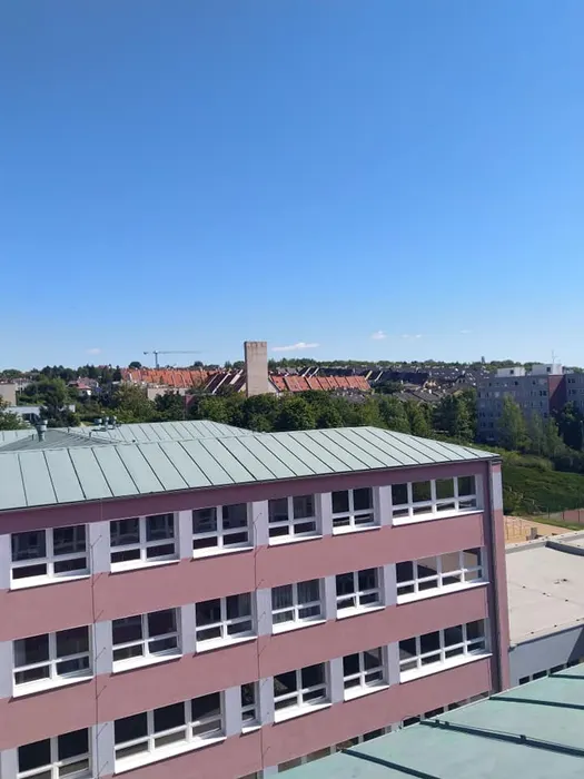 Budova s dokončeným nátěrem plechové střechy